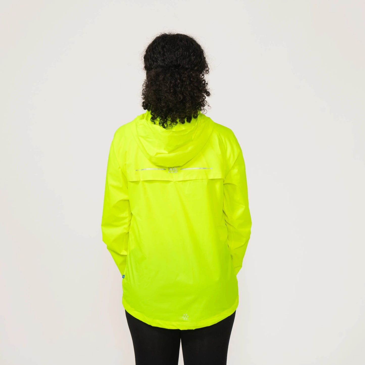 Person wearing a bright neon yellow waterproof and windproof rain jacket displaying the back on a plain background