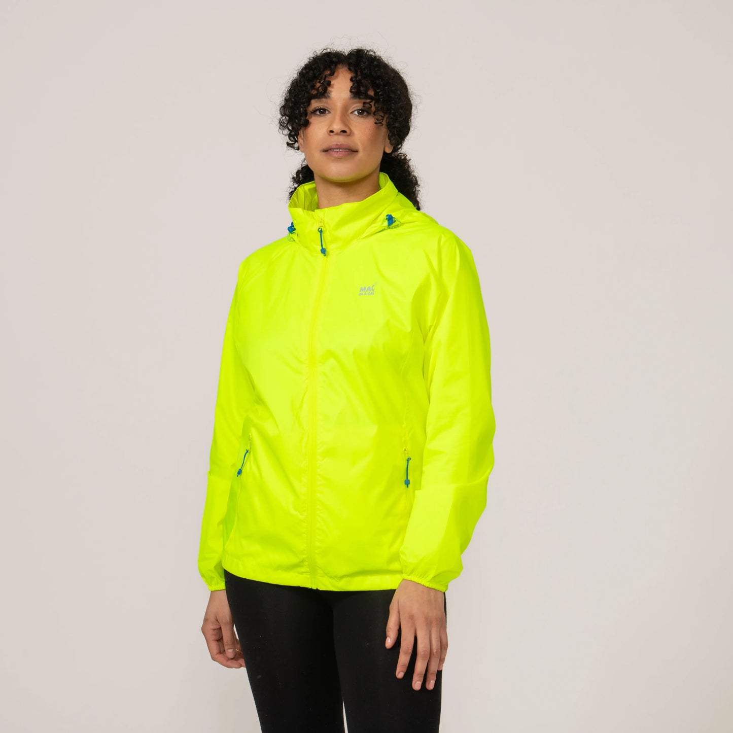Person wearing a bright neon yellow waterproof and windproof jacket displaying the length and fit on a plain background