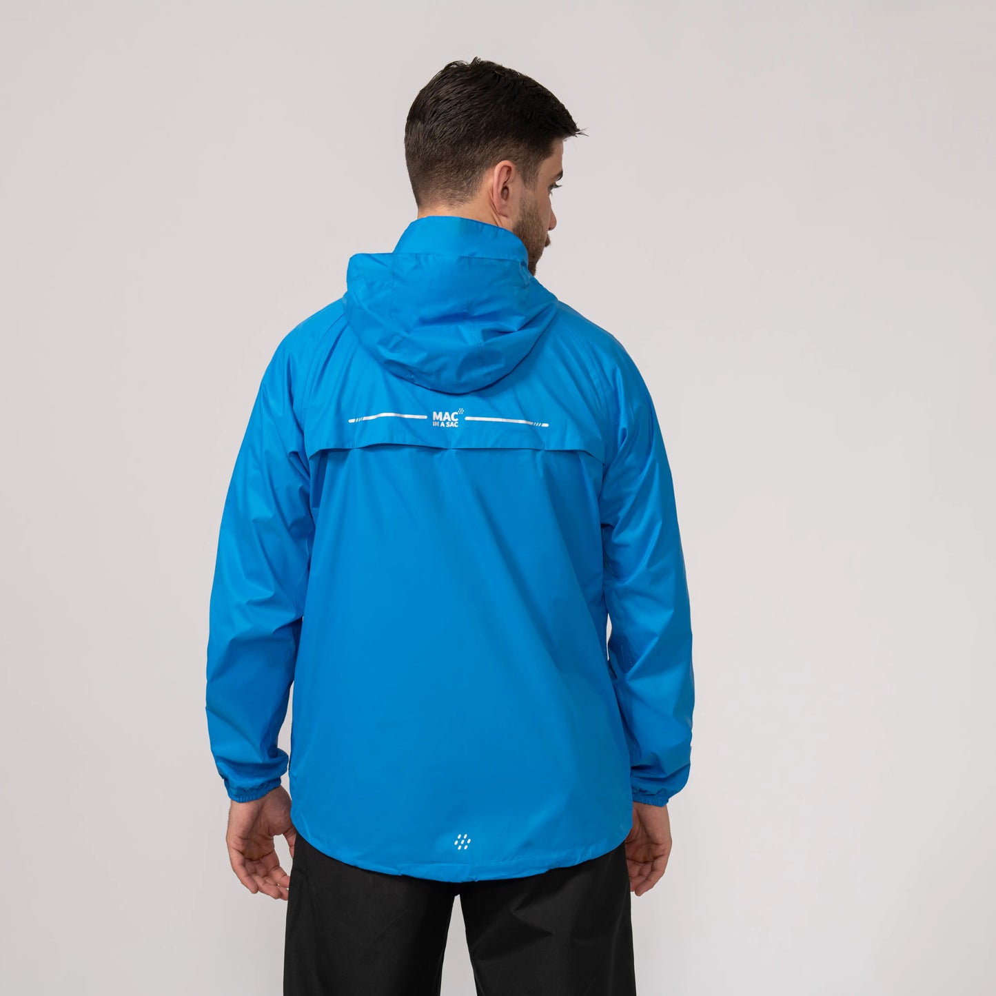 Person wearing a blue waterproof and windproof jacket showing the back with a logo on a plain background