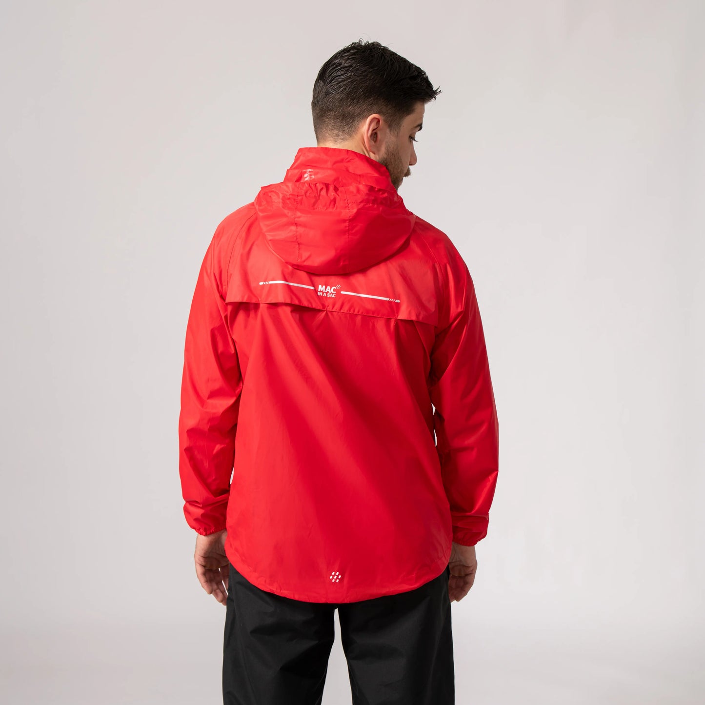 Person wearing a red waterproof and windproof jacket with a visible brand logo on the back against a plain background